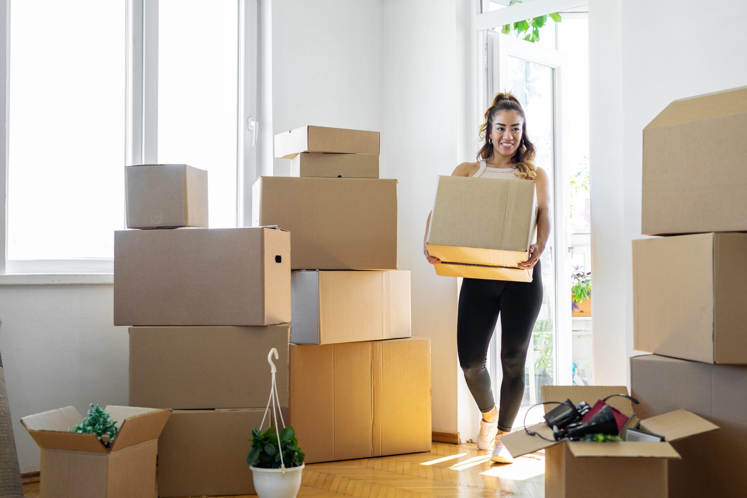 Woman carrying boxes into her new place Woman carrying boxes into her new place
